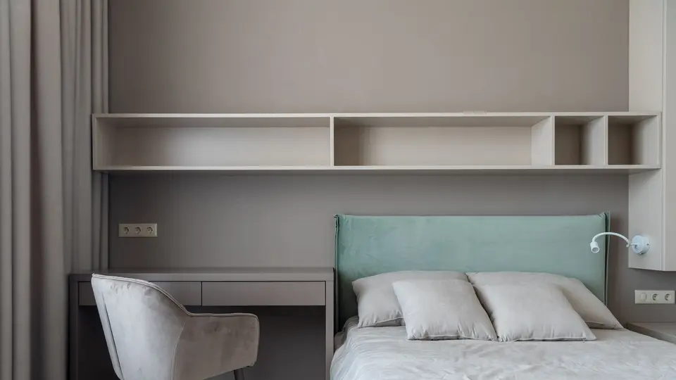 Foto ilustrasi kamar tidur dengan meja kerja dan tempat tidur berseprai putih