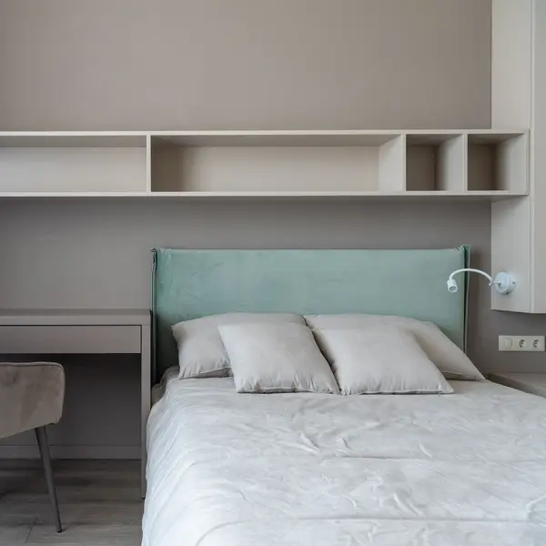 Foto ilustrasi kamar tidur dengan meja kerja dan tempat tidur berseprai putih