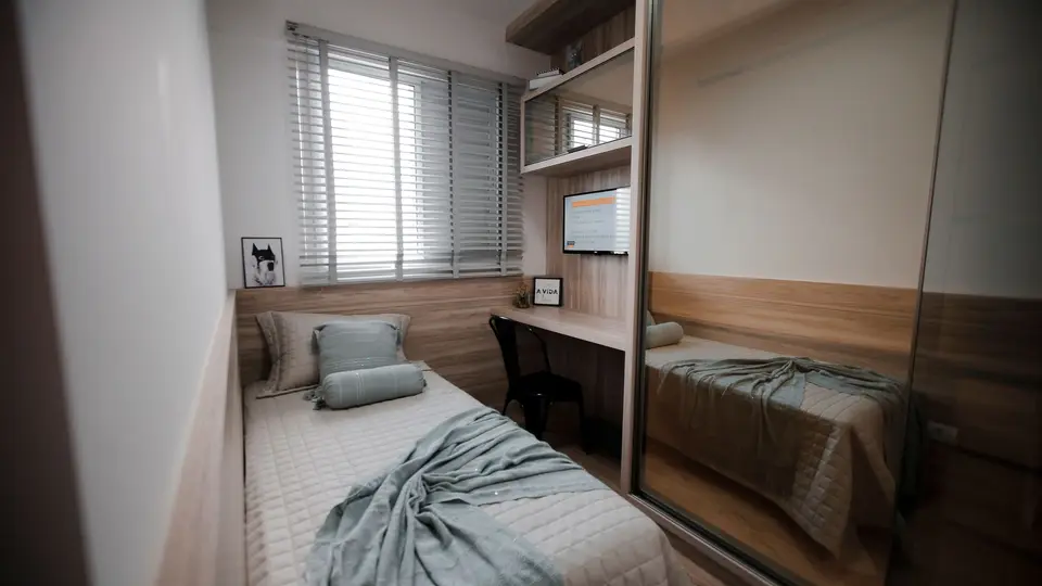 Foto ilustrasi kamar kompak dengan tempat tidur, meja, dan lemari