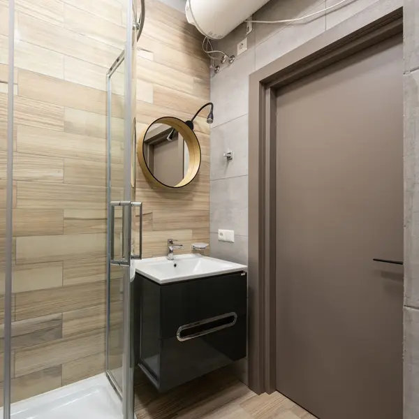 Foto ilustrasi kamar mandi dengan shower kaca dan pemanas air